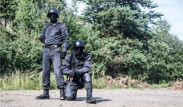 Hard Shell tactical officers equipped with ballistic helmets and protective gear during outdoor training for security and defense operations.