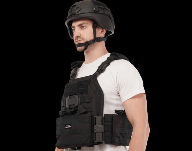 Man wearing Hard Shell TacSnap Plate Carrier in black, showing side profile with tactical helmet and buckles.