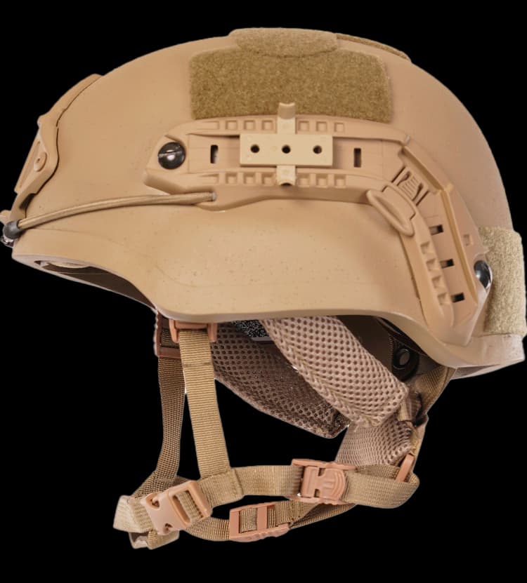 Profile view of a tan mid-cut tactical helmet with rail system, Velcro panels, and mesh interior padding.