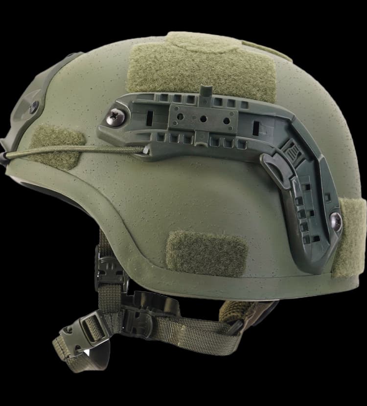 Side view of green MICH tactical helmet featuring Velcro patches and adjustable chin strap.