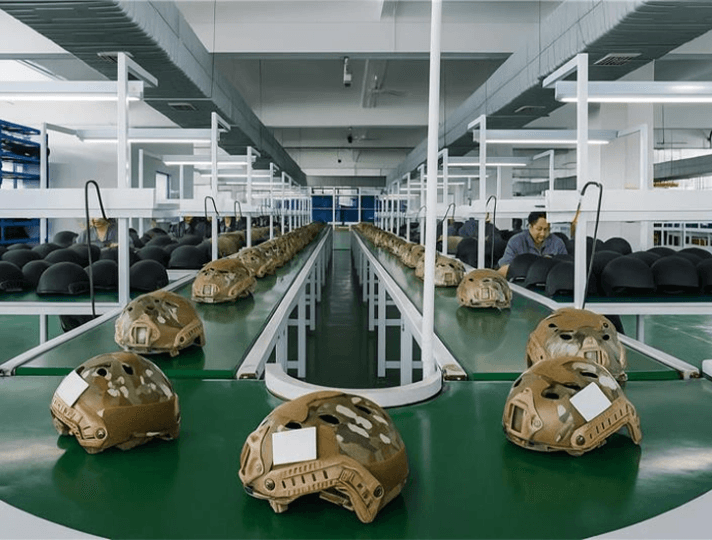 Military helmets on a production line in a defense manufacturing facility ensuring quality and precision engineering.