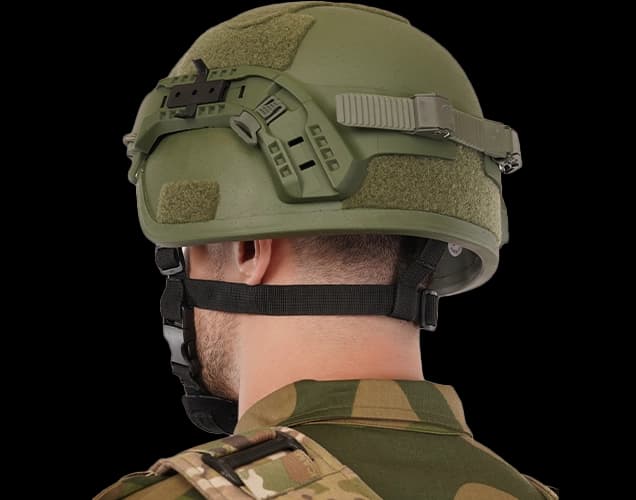 Rear view of a soldier wearing a boltless ballistic helmet with retention strap and accessory rails.