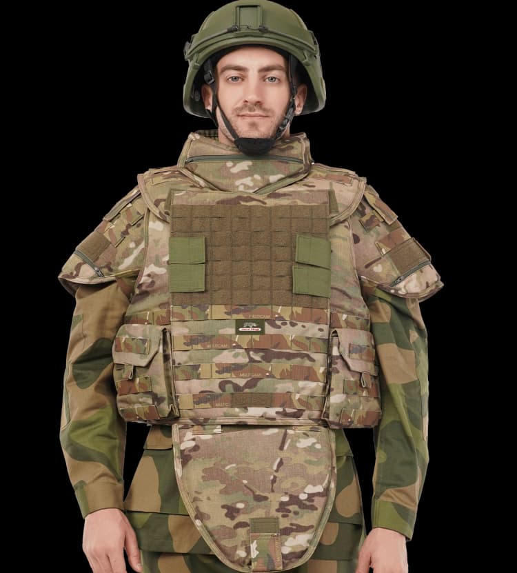 Man wearing Hard Shell camouflage Patron Vest with ballistic helmet, featuring MOLLE webbing and full-body tactical protection.