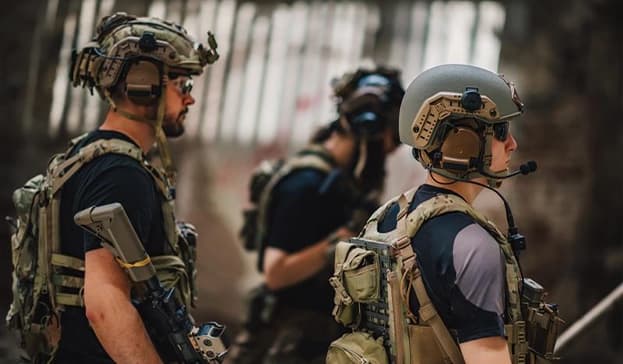 Special forces soldiers wearing tactical helmets, ballistic vests, and communication gear during a military operation.
